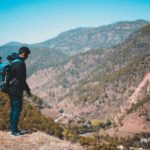 man backpacking through nature on a mountain