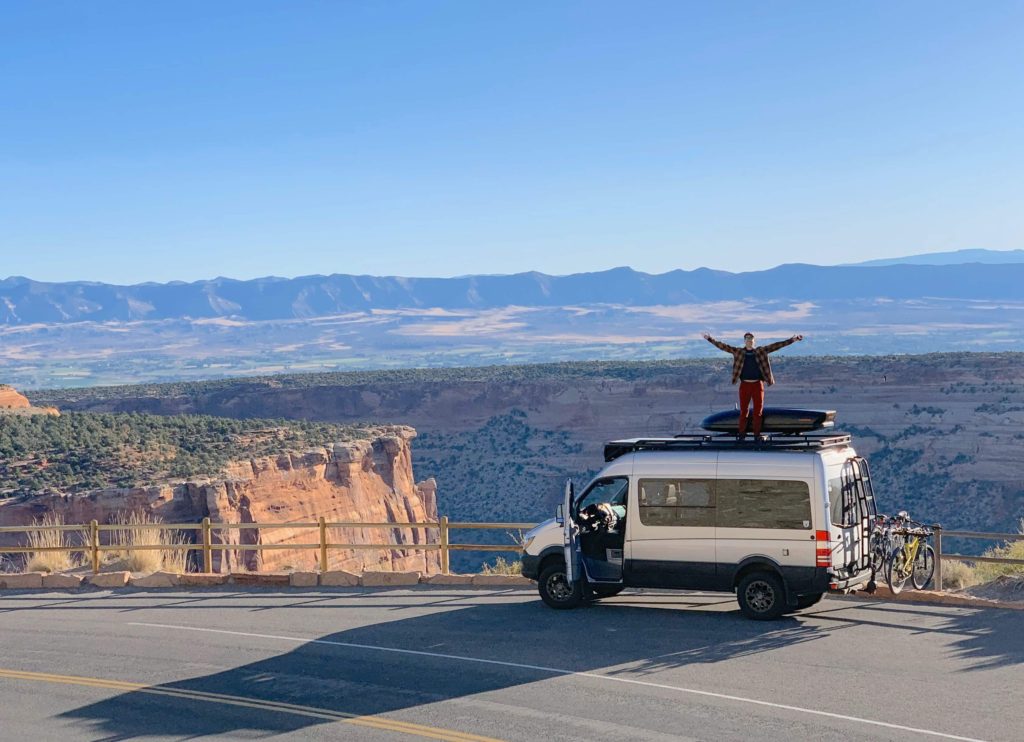 Man standing on top of his camper van conversion