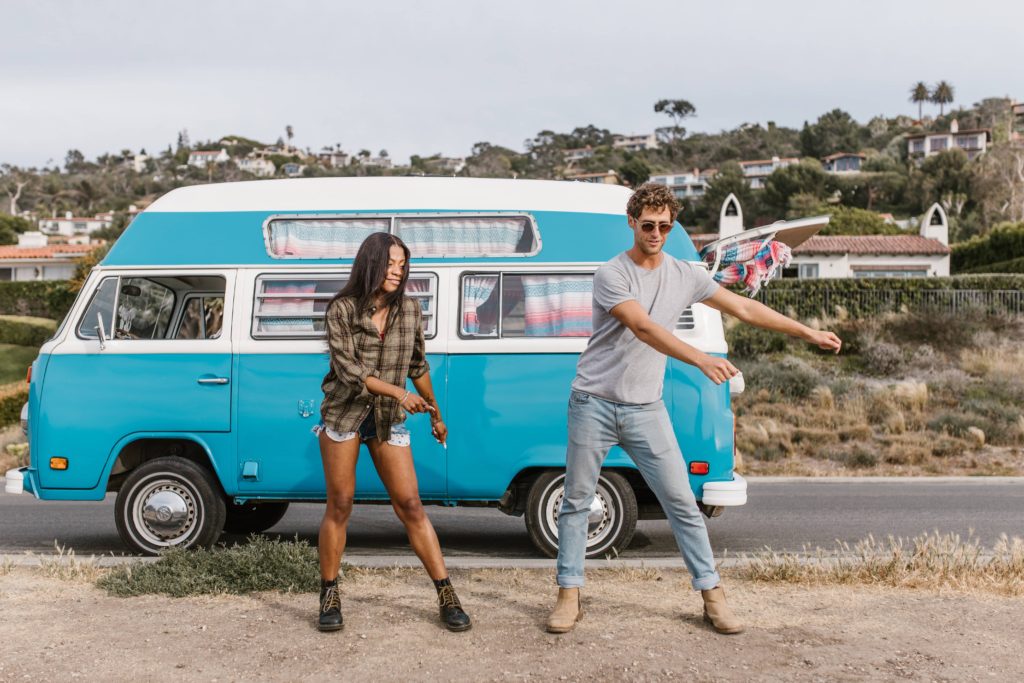 VanLife Couple staying fit with vanlife in front of their van exercising. 