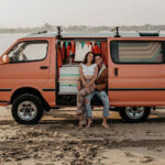 vanlife couple on a beach