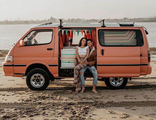 vanlife couple on a beach